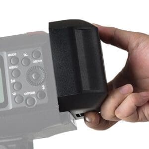 Hand attaching battery to the back of a studio strobe on a white background